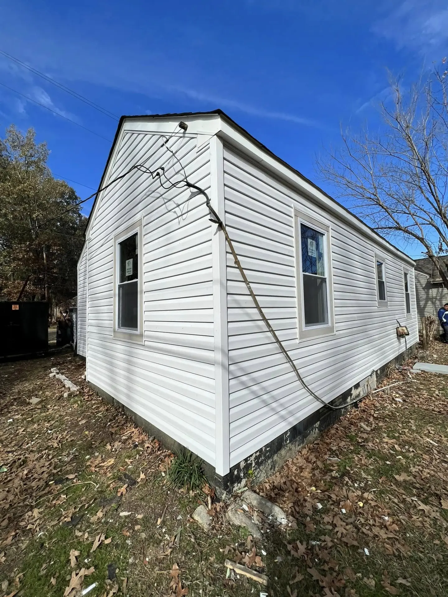 Completed white vinyl siding installation on a renovated home exterior