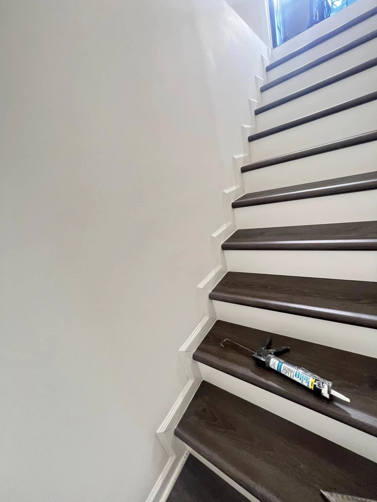 Staircase with dark walnut treads and white risers and trim
