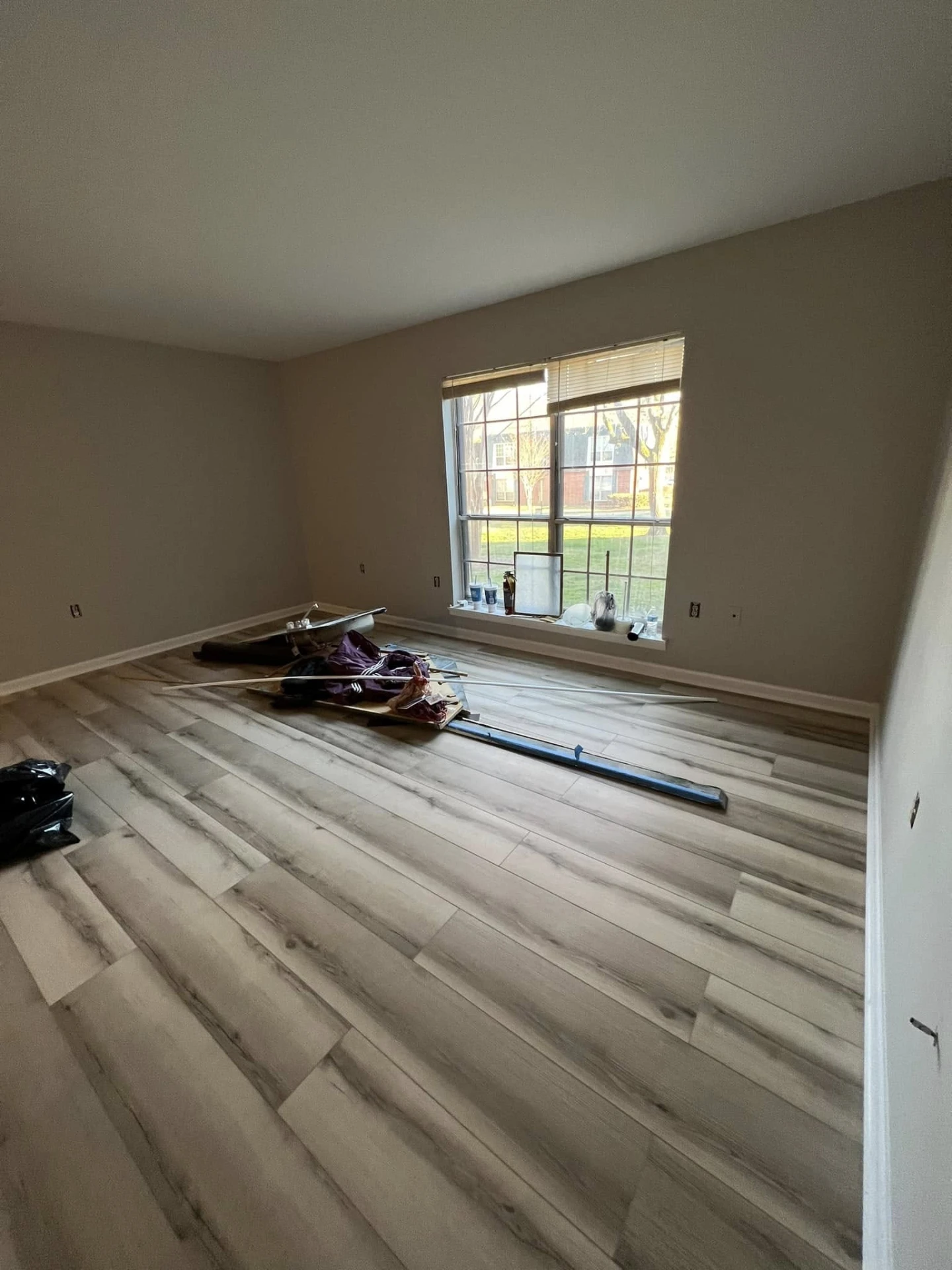 Bedroom with new wood-look plank flooring during installation